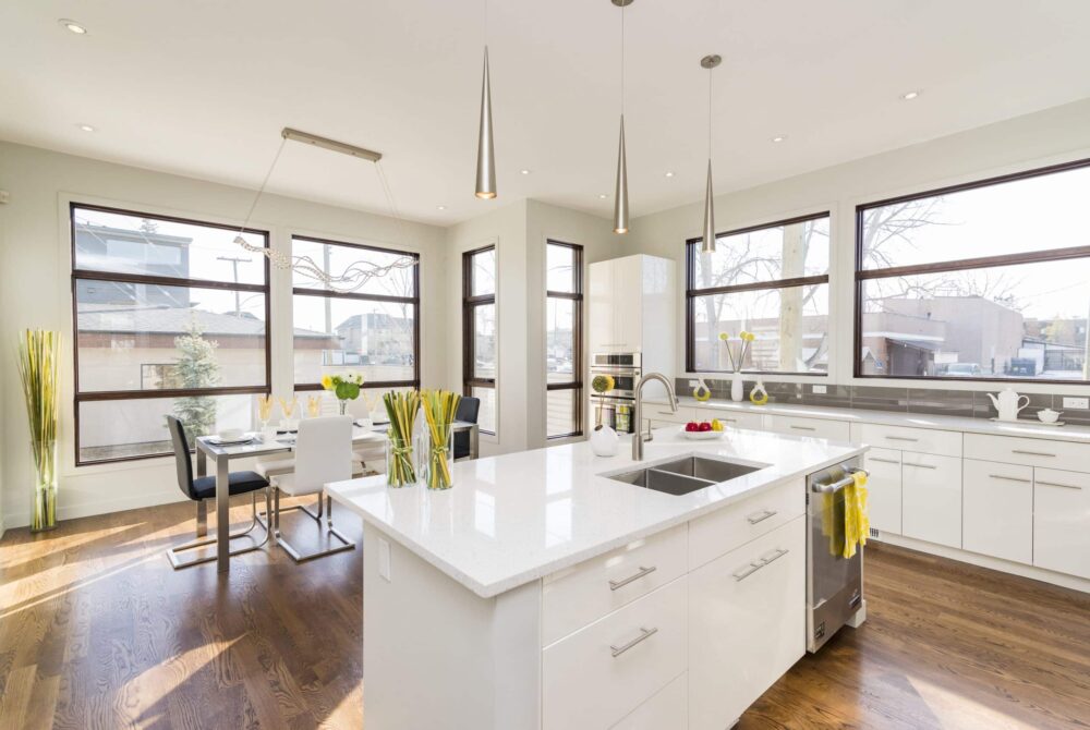 white kitchen island An interior shot of a modern house kitchen with large windows
