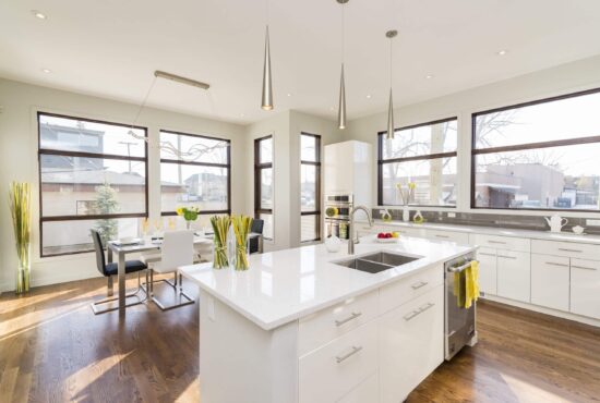 white kitchen island An interior shot of a modern house kitchen with large windows