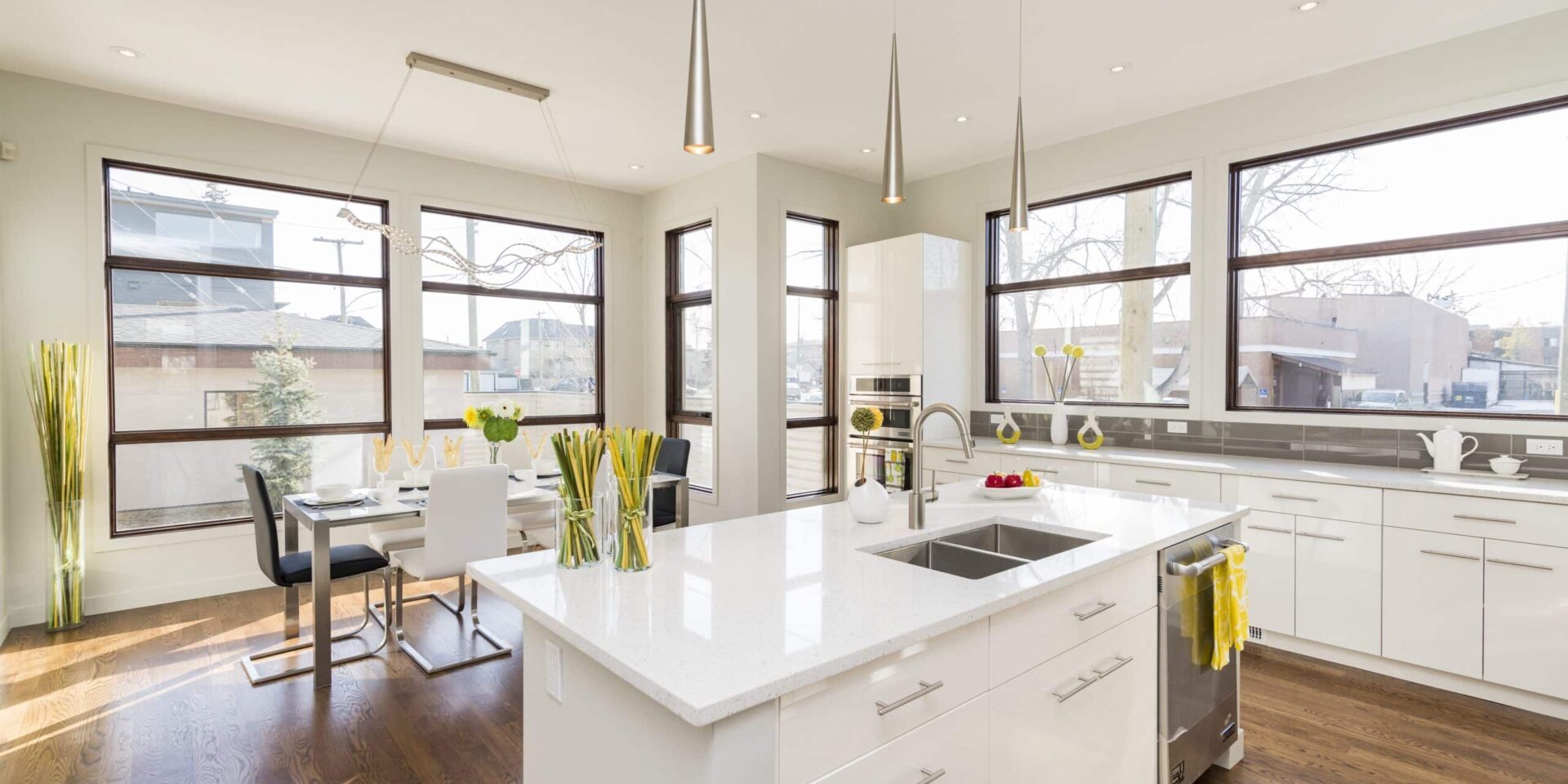 white kitchen island An interior shot of a modern house kitchen with large windows