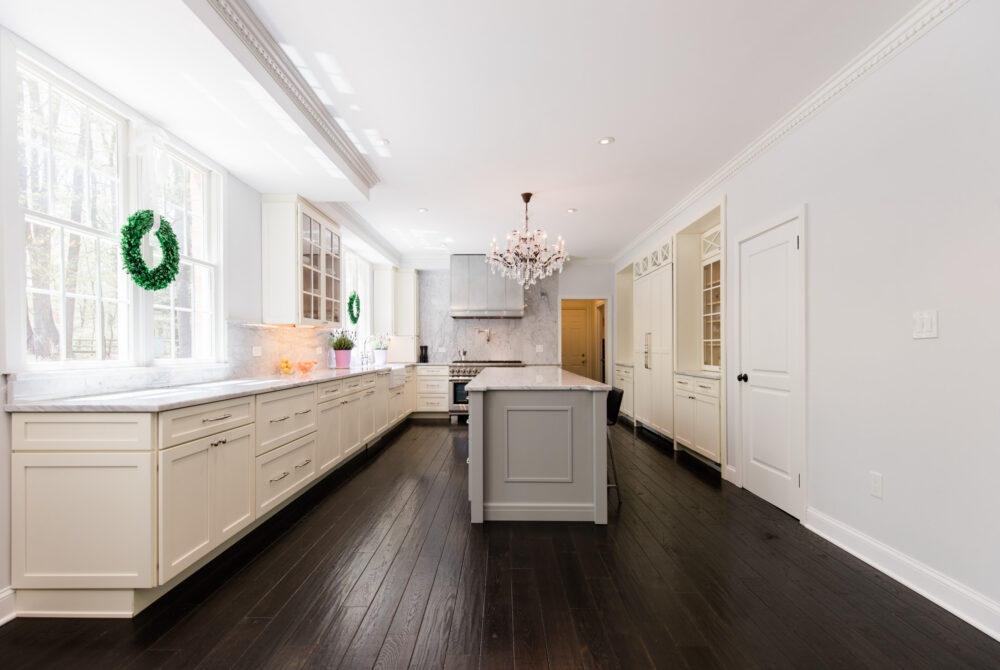 Kitchen remodeling in Vienna VA featuring white shaker cabinets, marble backsplash, center island, chandelier lighting, and dark hardwood floors