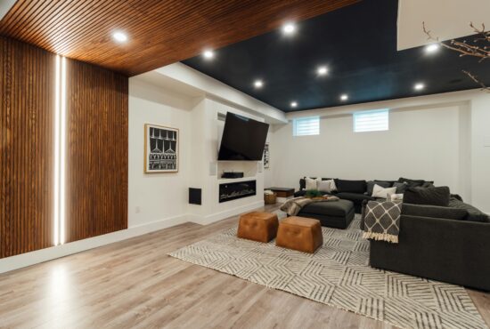 Finished basement family room with luxury vinyl flooring, light walls, and recessed lighting