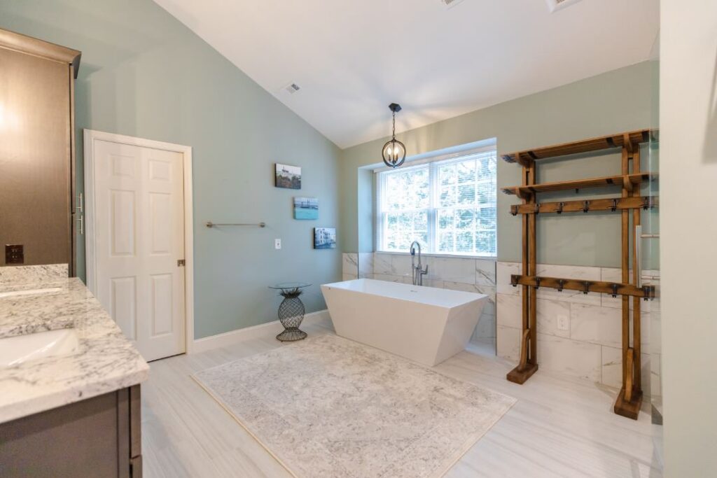 Freestanding bathtub positioned beside a bathroom window