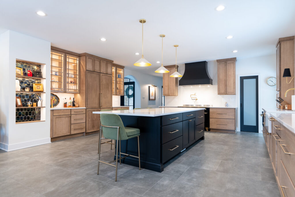 Kitchen with a black center island and white oak perimeter cabinets along the walls